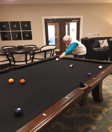 Senior woman shooting pool