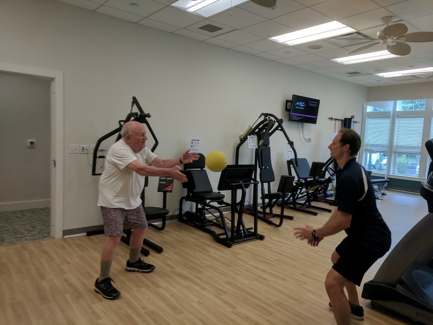 physical rehab 2 men tossing yellow ball for therapy
